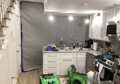 Dehumidifier and air mover running in a Metairie room during drying