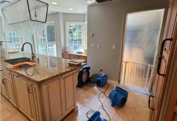 Air movers and a dehumidifier drying a water-damaged room in Metairie
