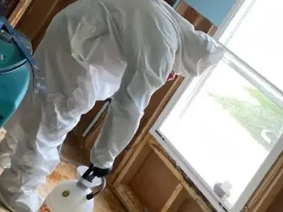 Technician in protective gear cleaning a sewage backup in Metairie