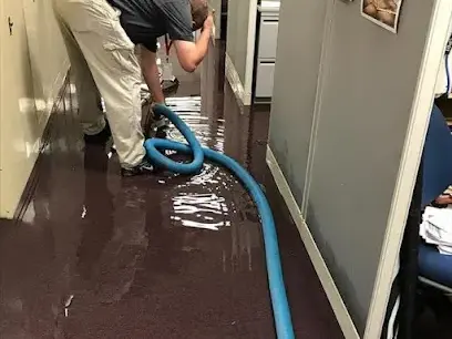 Extraction wand pulling standing water off a flooded floor in a Metairie home